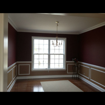 Formal dining room with burgundy walls, white wainscoting, hardwood floors, and large window