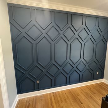 Dark blue accent wall with geometric hexagonal and diamond pattern molding in modern interior space