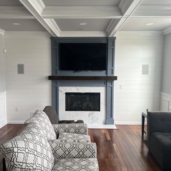 Modern living room with fireplace and TV mounted above in built-in entertainment center