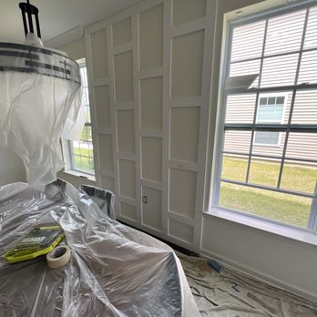 Interior room with plastic sheeting, drop cloth, and painting supplies near closed doors and window